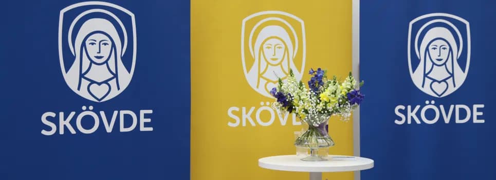 Ett bord med en vas med blommor på.
