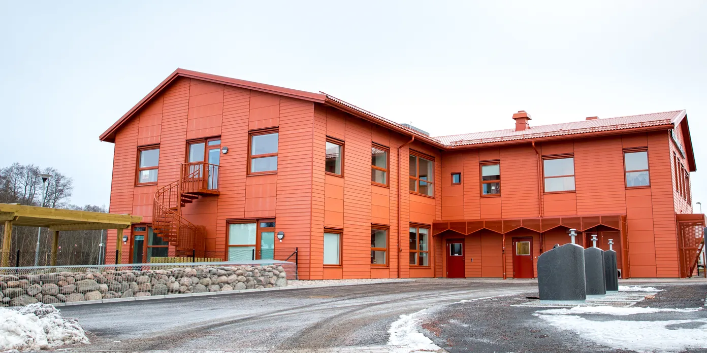 En stor orange byggnad med rött tak