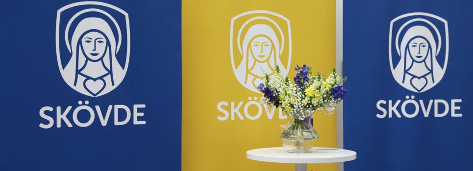 Ett bord med en vas med blommor på.