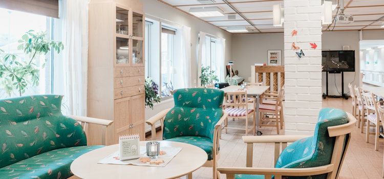 Ett vardagsrum fyllt med möbler och många fönster