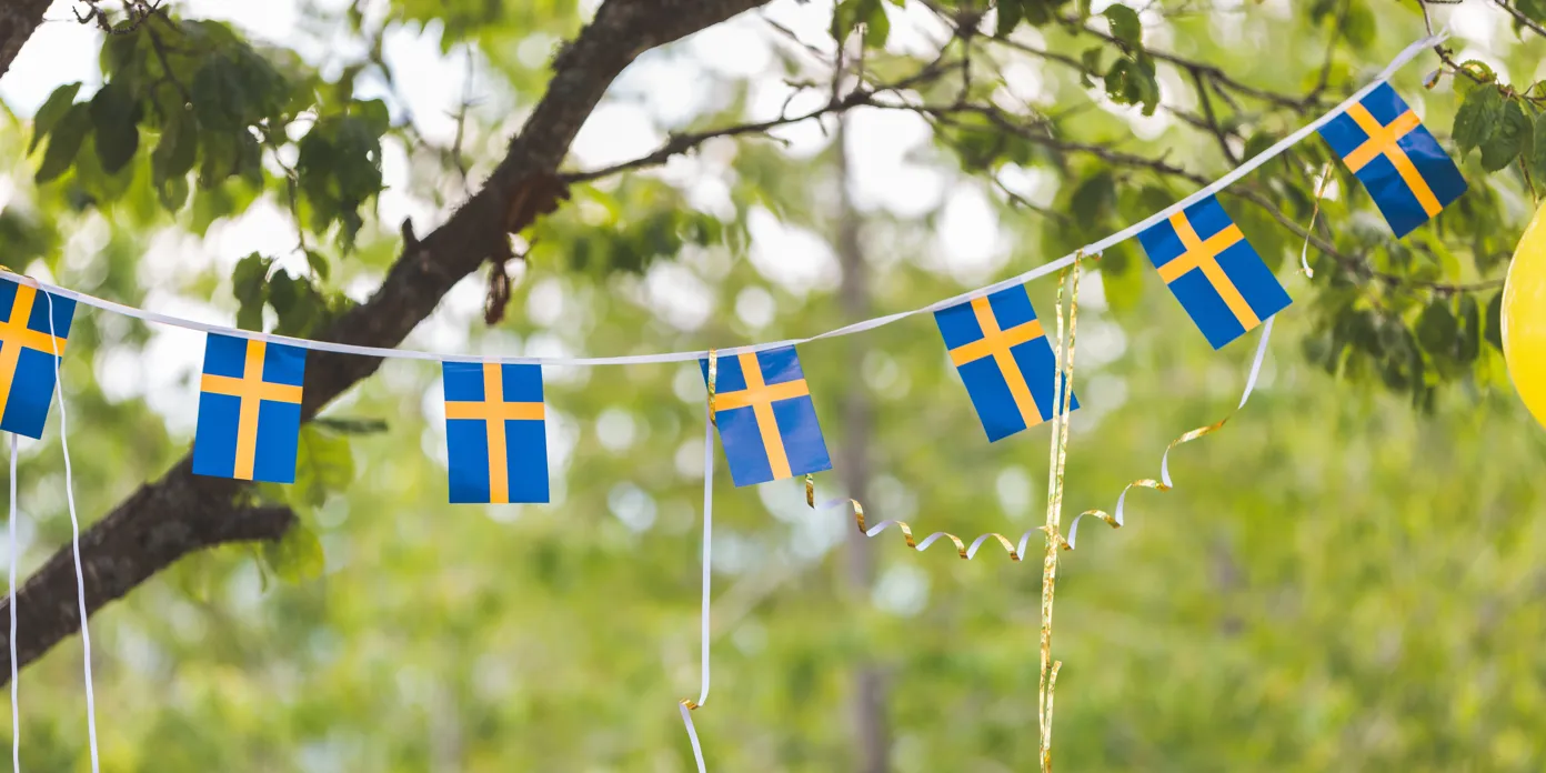Ett gäng blågula flaggor som hänger i ett träd.