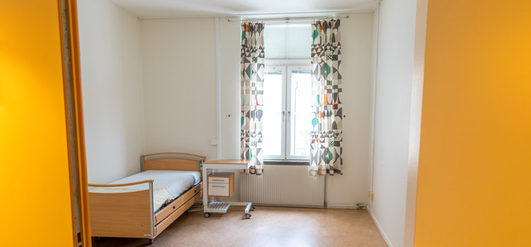 Ett sovrum med en säng och ett fönster