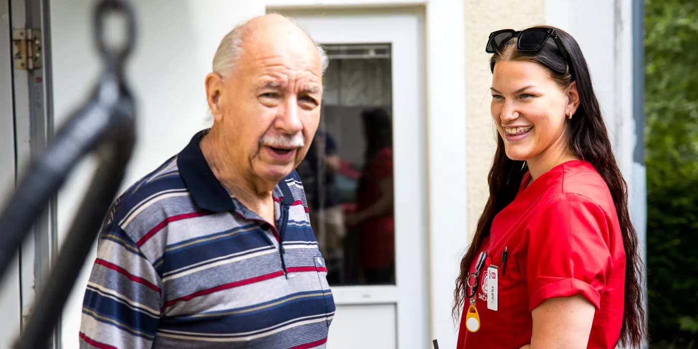 En man och en medarbetare står utanför ett hus