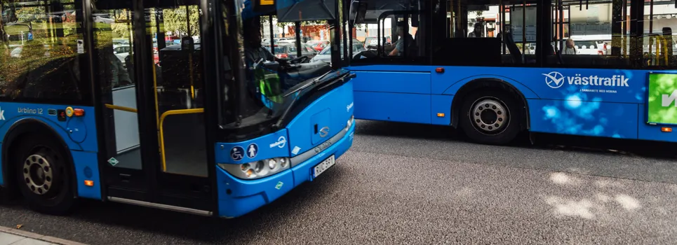 Några blå bussar parkerade bredvid varandra.