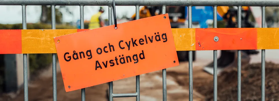 En byggarbetsplats med byggutrustning bakom ett staket.